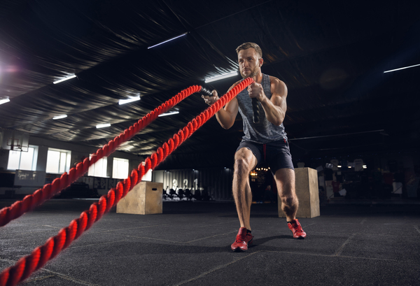 young healthy man athlete doing exercise with ropes gym single male model practicing hard training his upper body concept healthy lifestyle sport fitness bodybuilding wellbeing 1 The Ultimate Guide to CrossFit Gyms: Achieve Your Fitness Goals